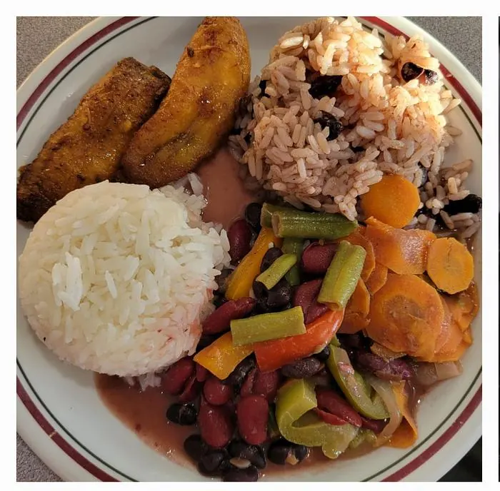 Three bean plate with rice, vegetables, and fried plantains